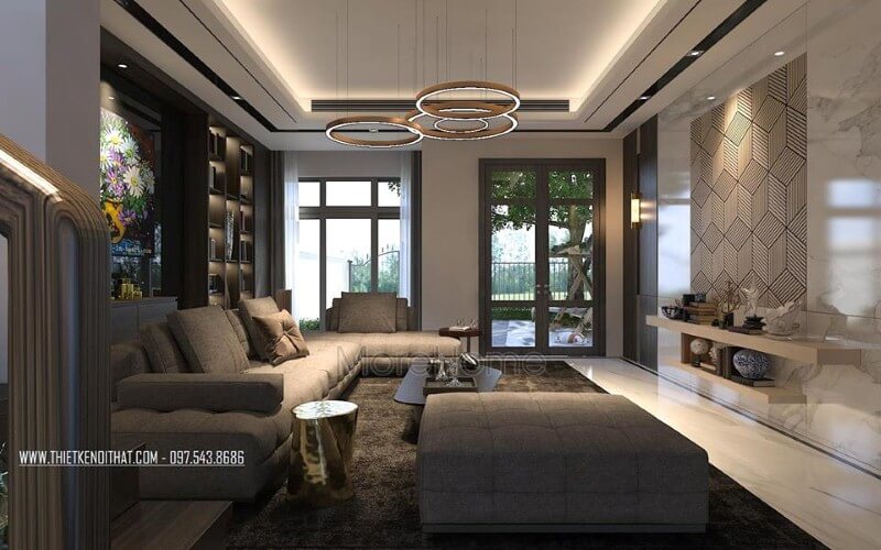 Trang trí nội thất phòng khách ấn tượng với cách kết hợp hài hòa giữa sắc trầm và sáng cùng hệ cửa kính lớn giúp không gian trở nên thông thoáng, sang trọng. Mẫu nội thất biệt thự đẹp